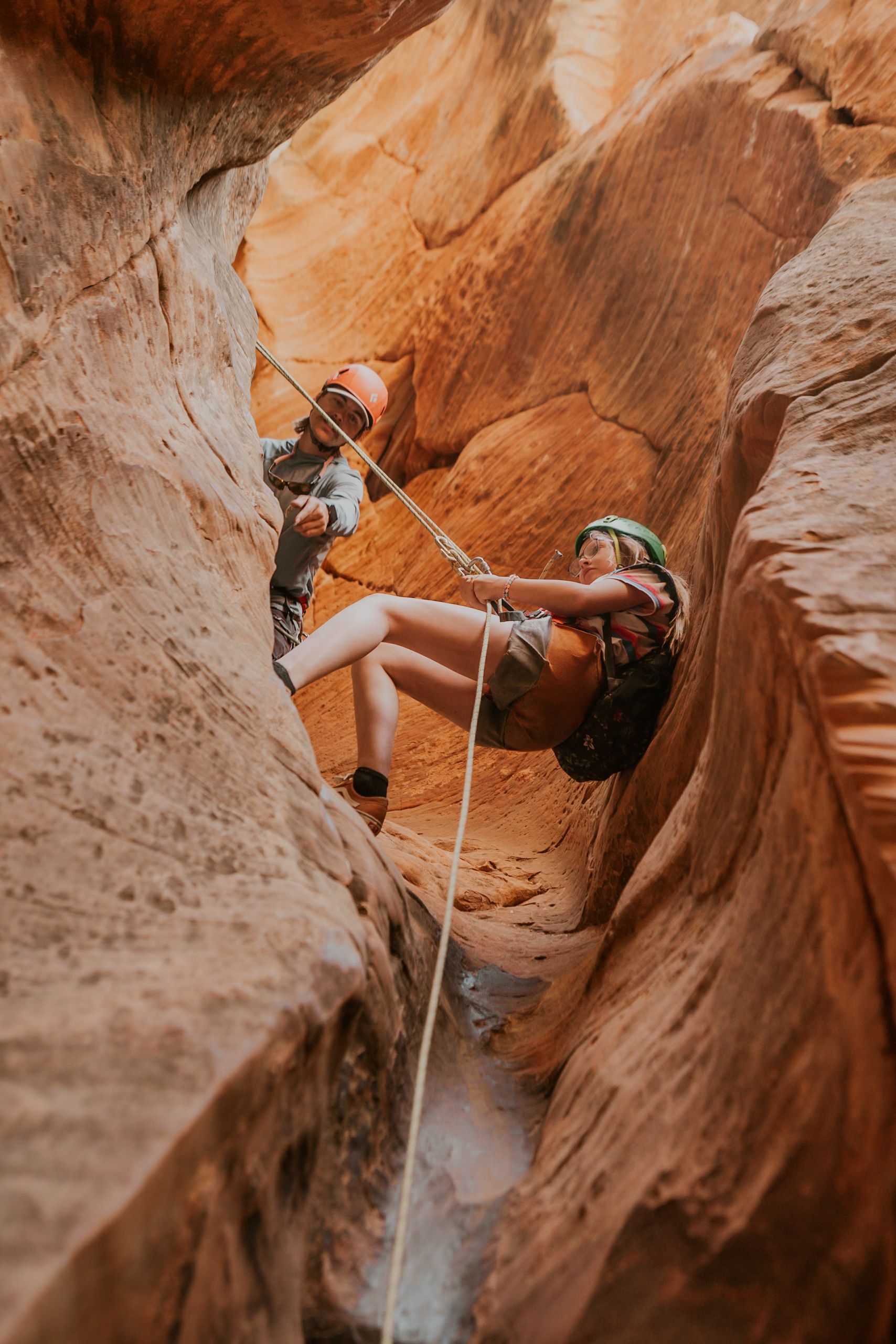 A person is sitting on a rock with their feet on a rope.