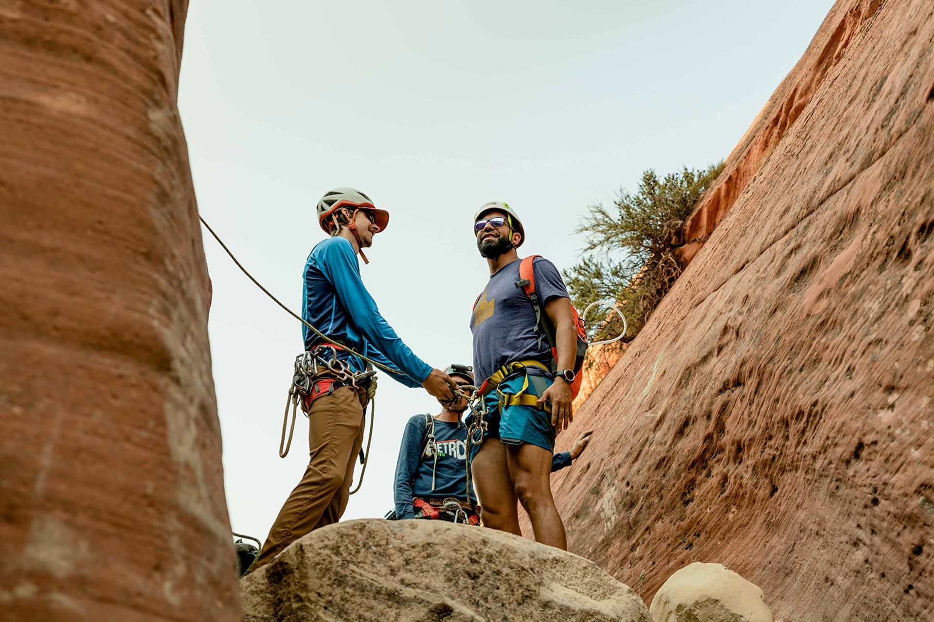 3 people learning rappelling safety techniques