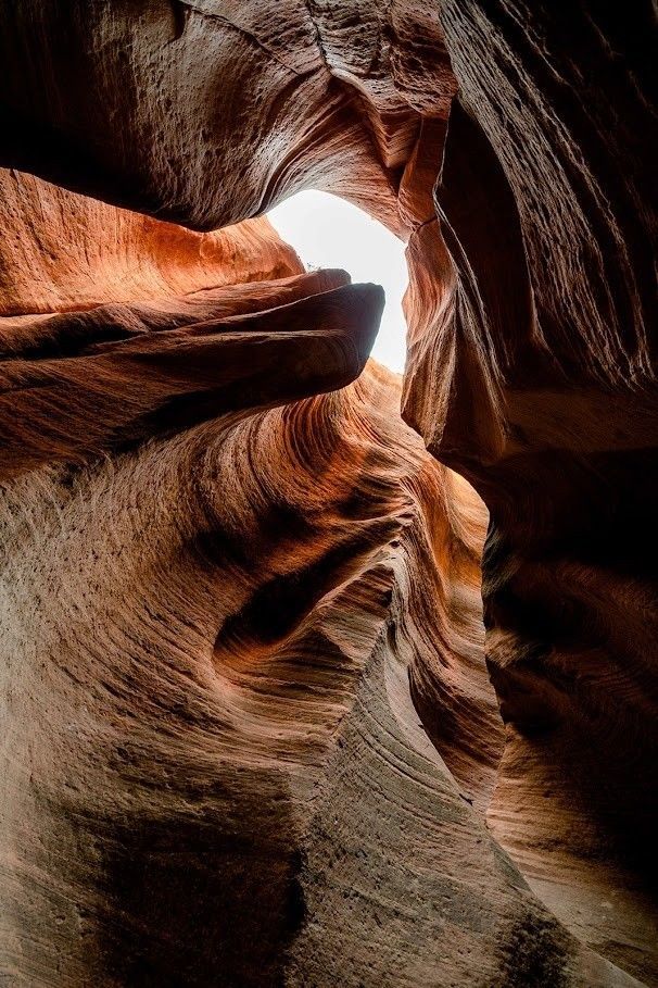 A canyon with a light coming out of the end of it.