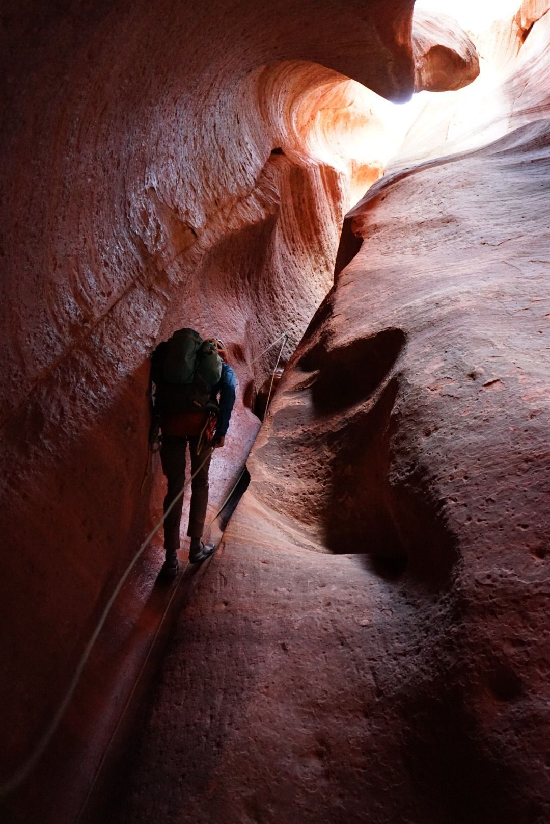 An All Ways Adventure Guide teaches a family how to rappel in an orange Navajo sandstone walls in a narrow slot canyon during a guided canyoneering trip with All Ways Adventure.