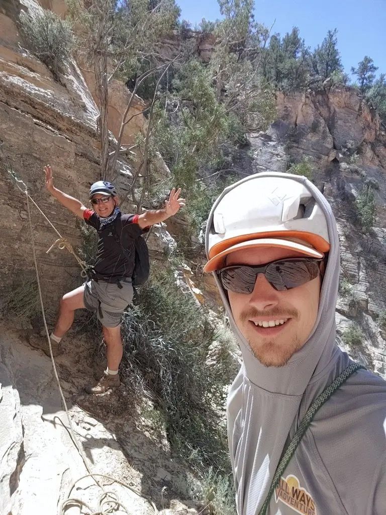 Two men hiking on a cliffside