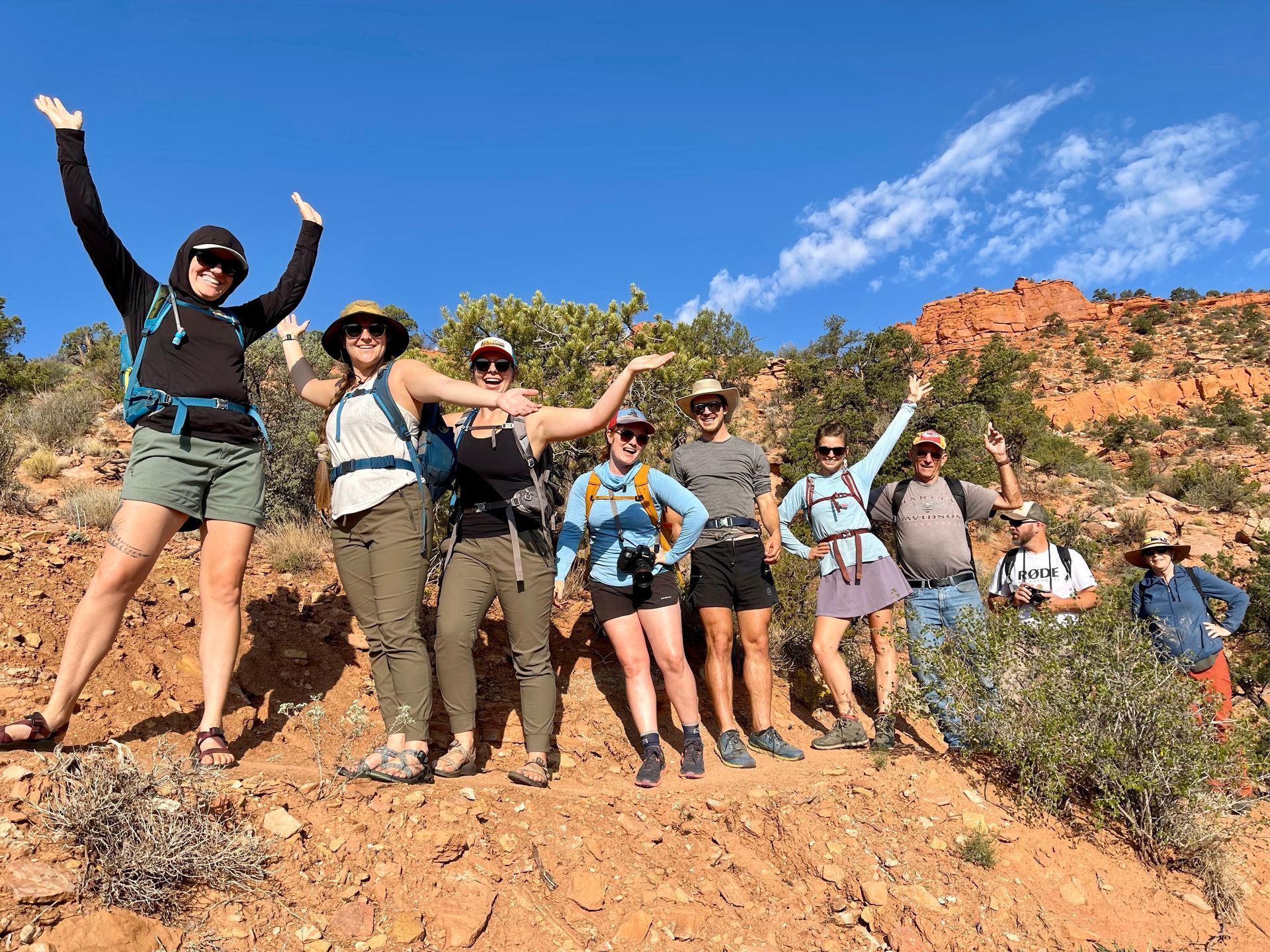 A woman in a blue jacket is holding onto a rope in a canyon