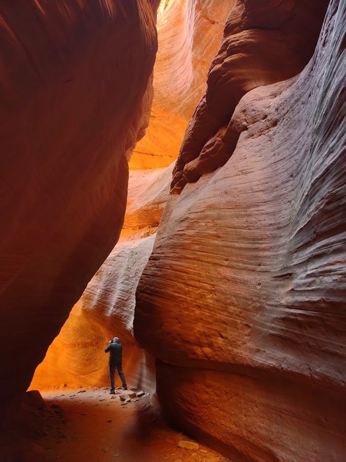 A silver suv is parked in the snow on a sunny day