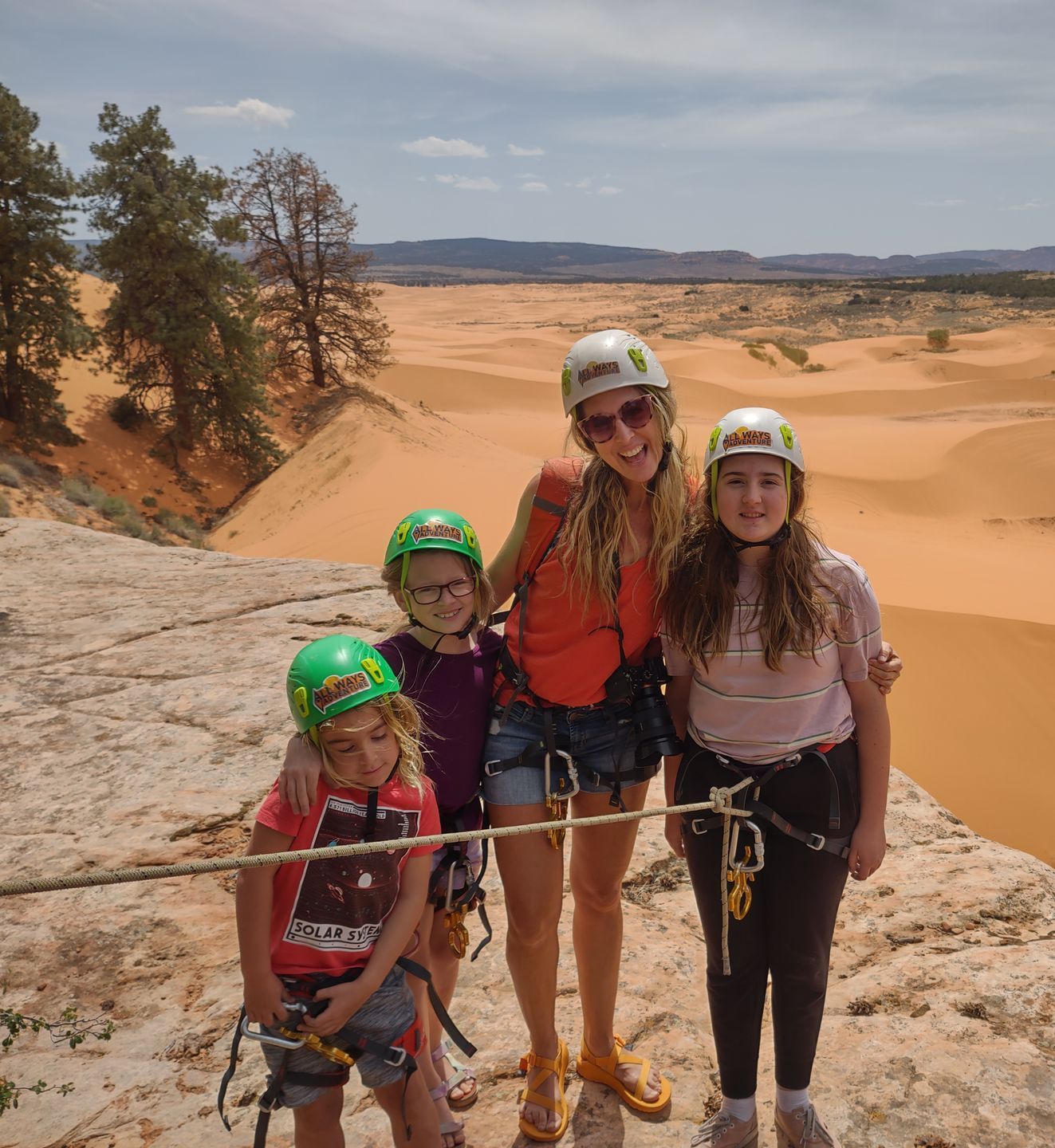 A family is standing on top of a rock in the desert.