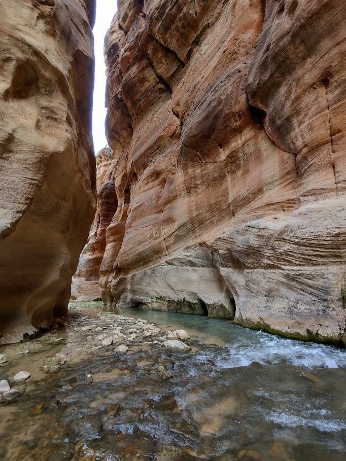 A river flowing between red sandstone walls.