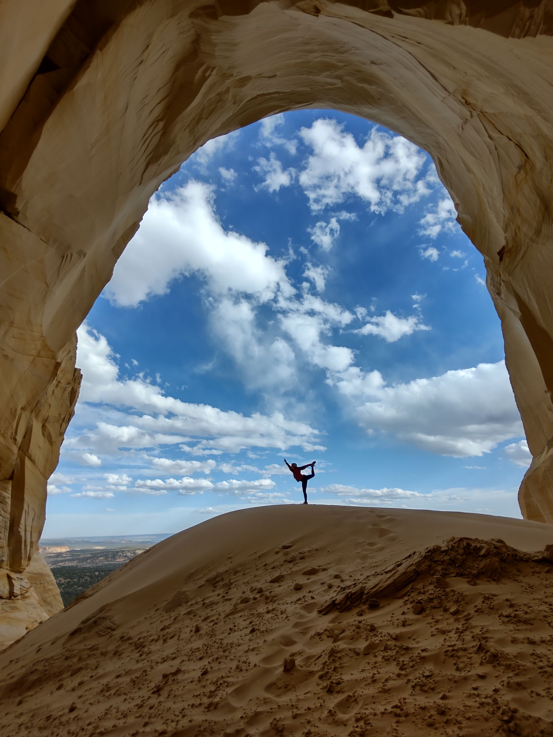 A person standing inside the massive, sun-lit Great Chamber alcove near Kanab, Utah, during a private All Ways Adventure off-road tour.