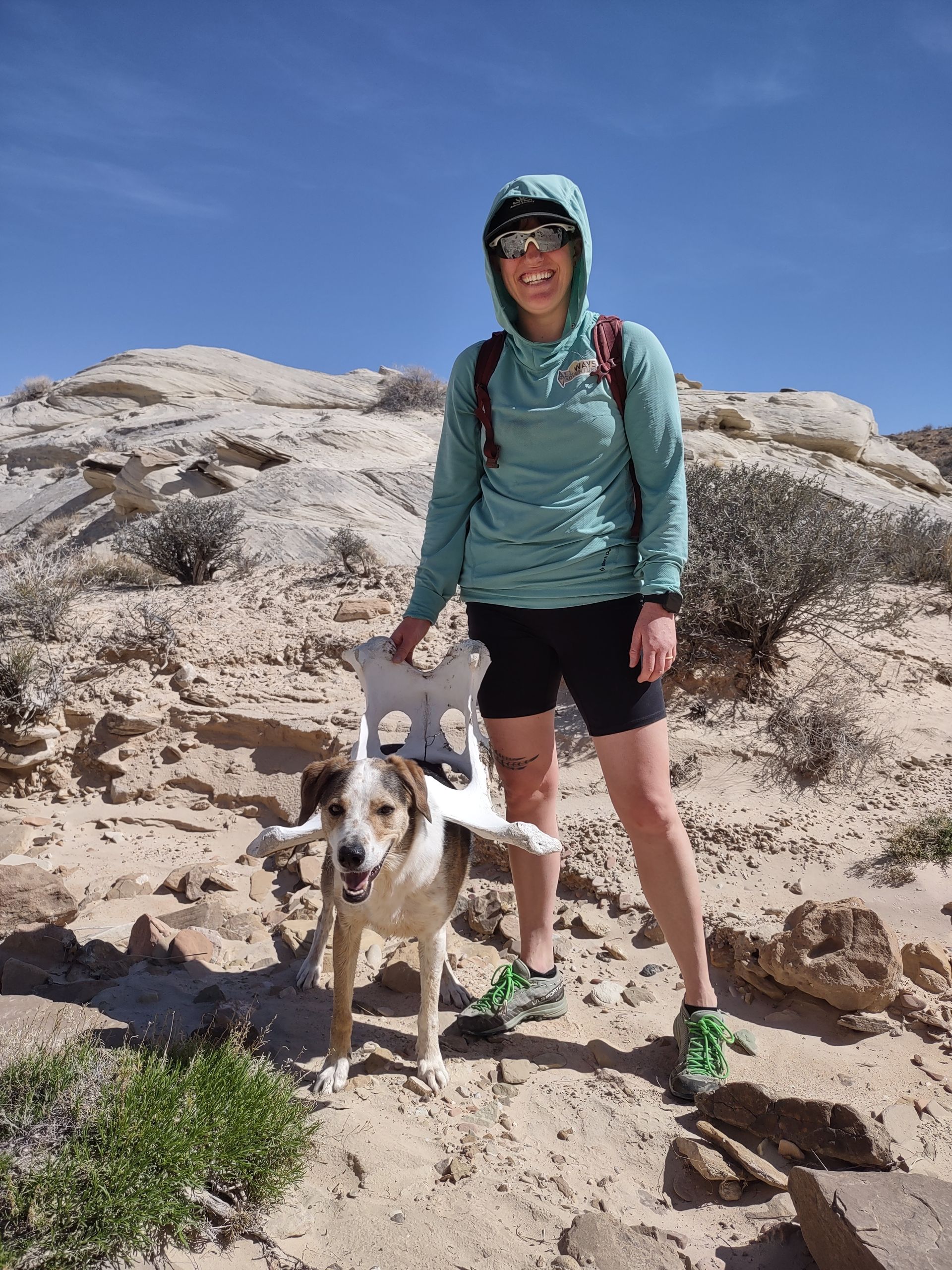 Jillian & Wren are posing for a photo with a skeleton pelvis balanced on Wren's back