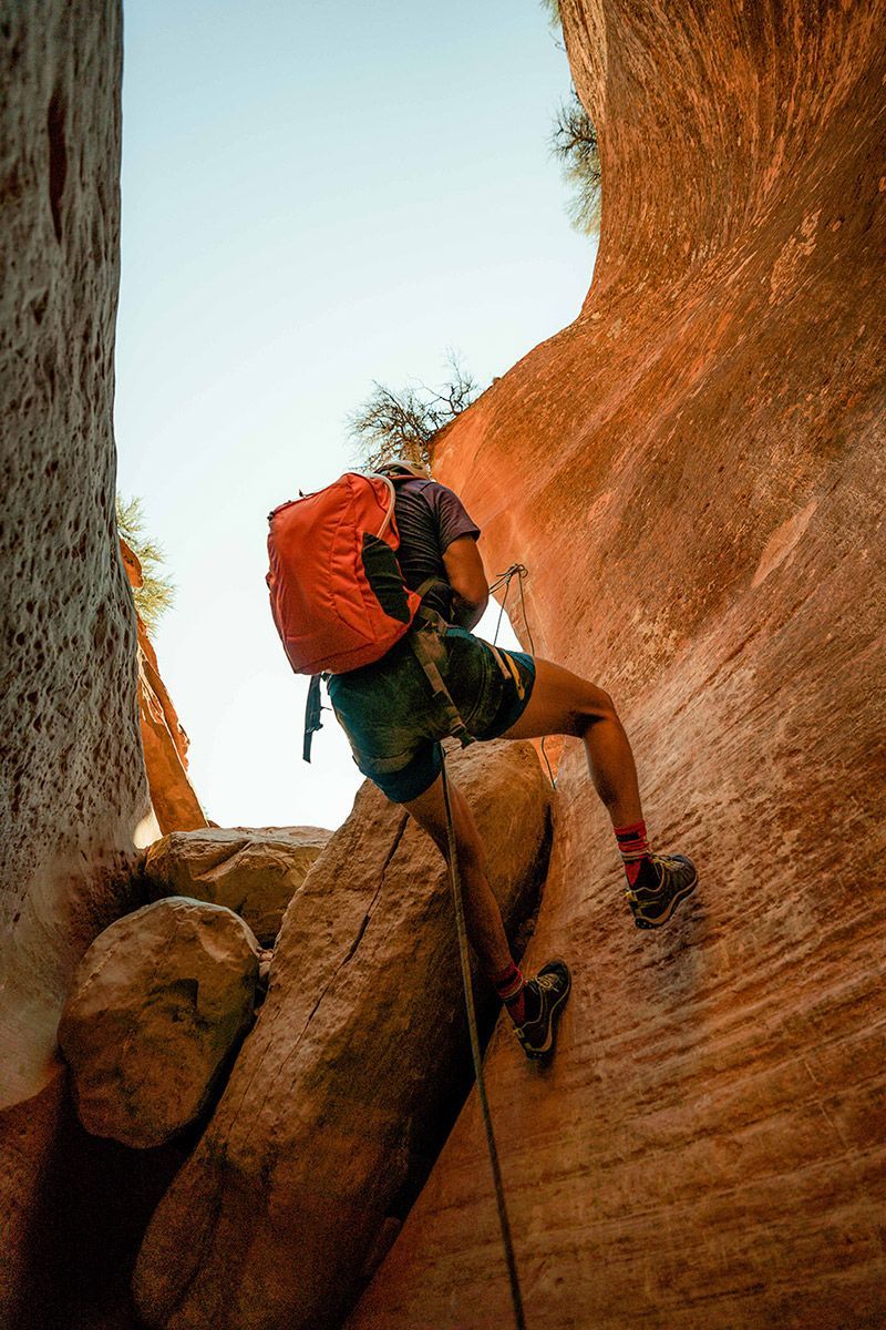 Man climbing with a rope.