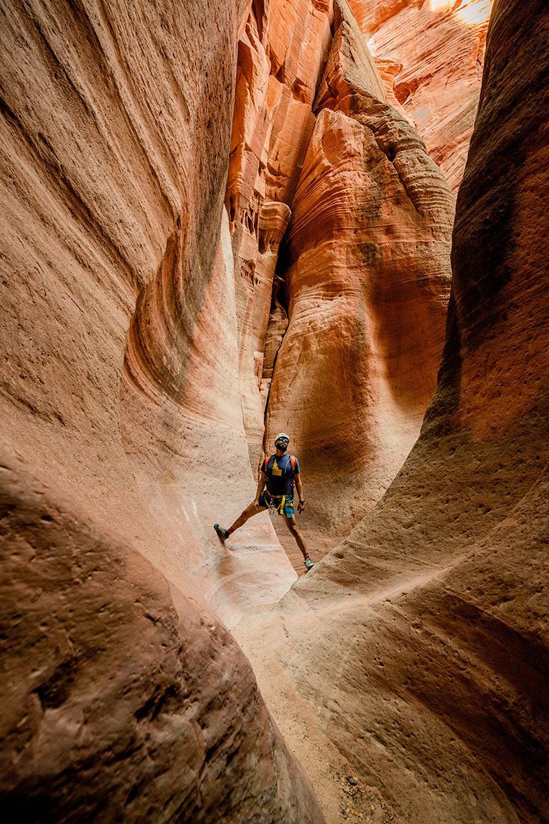 A man is standing in the middle of a canyon.