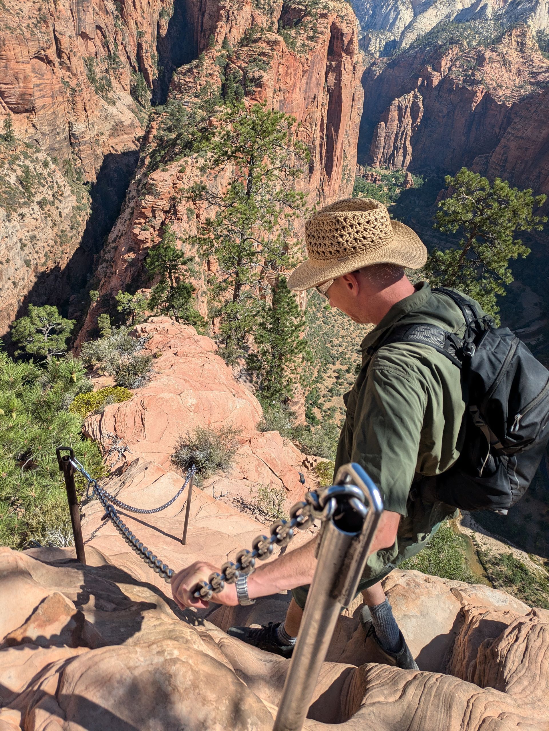 A man in a straw hat is climbing a rope ladder