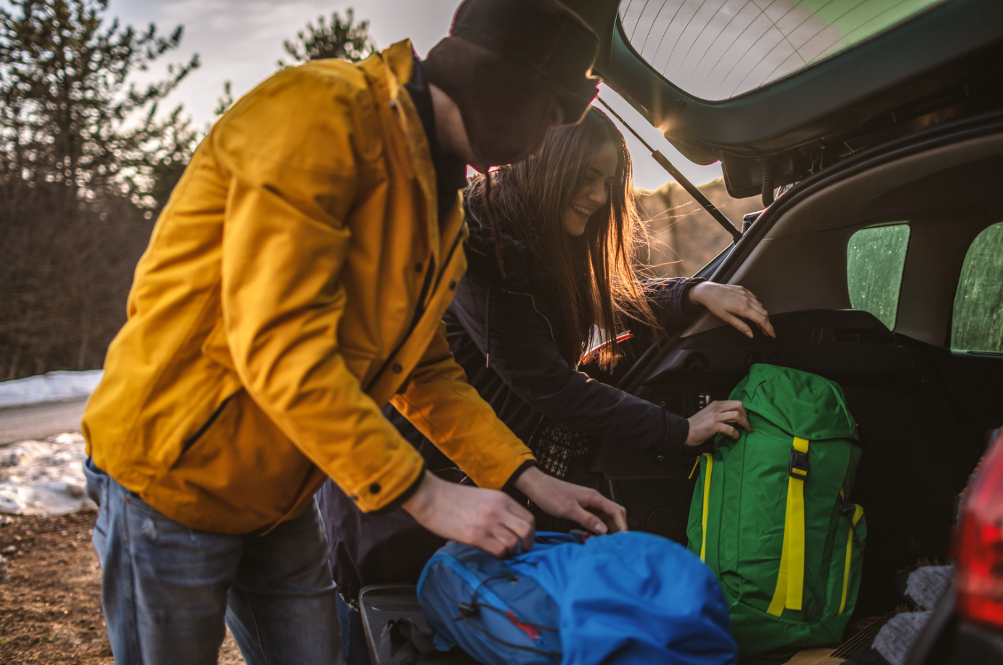 man and woman packing a car