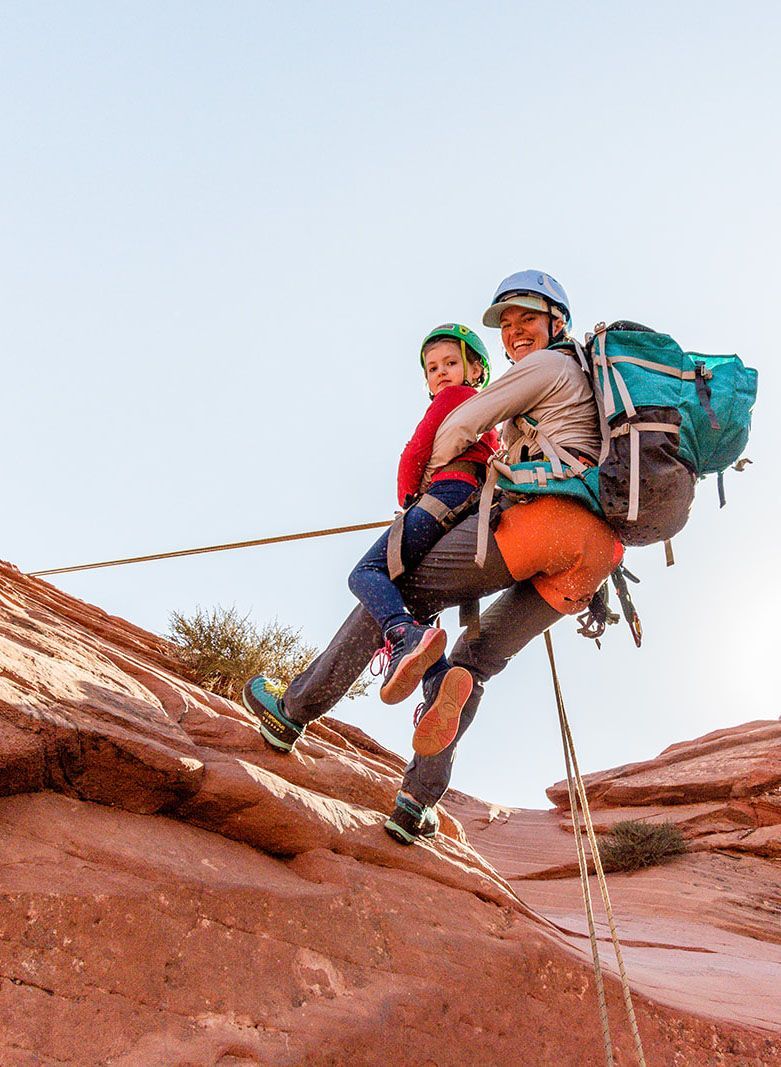 A woman and a child are climbing a rock wall.