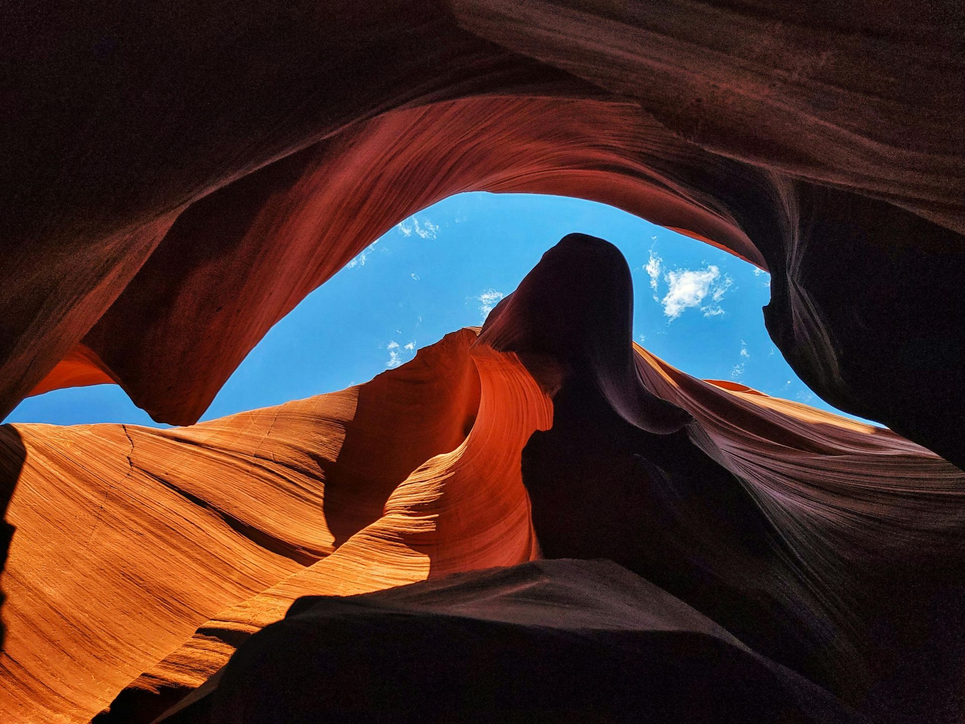 A silver suv is parked on a dirt road in the desert.