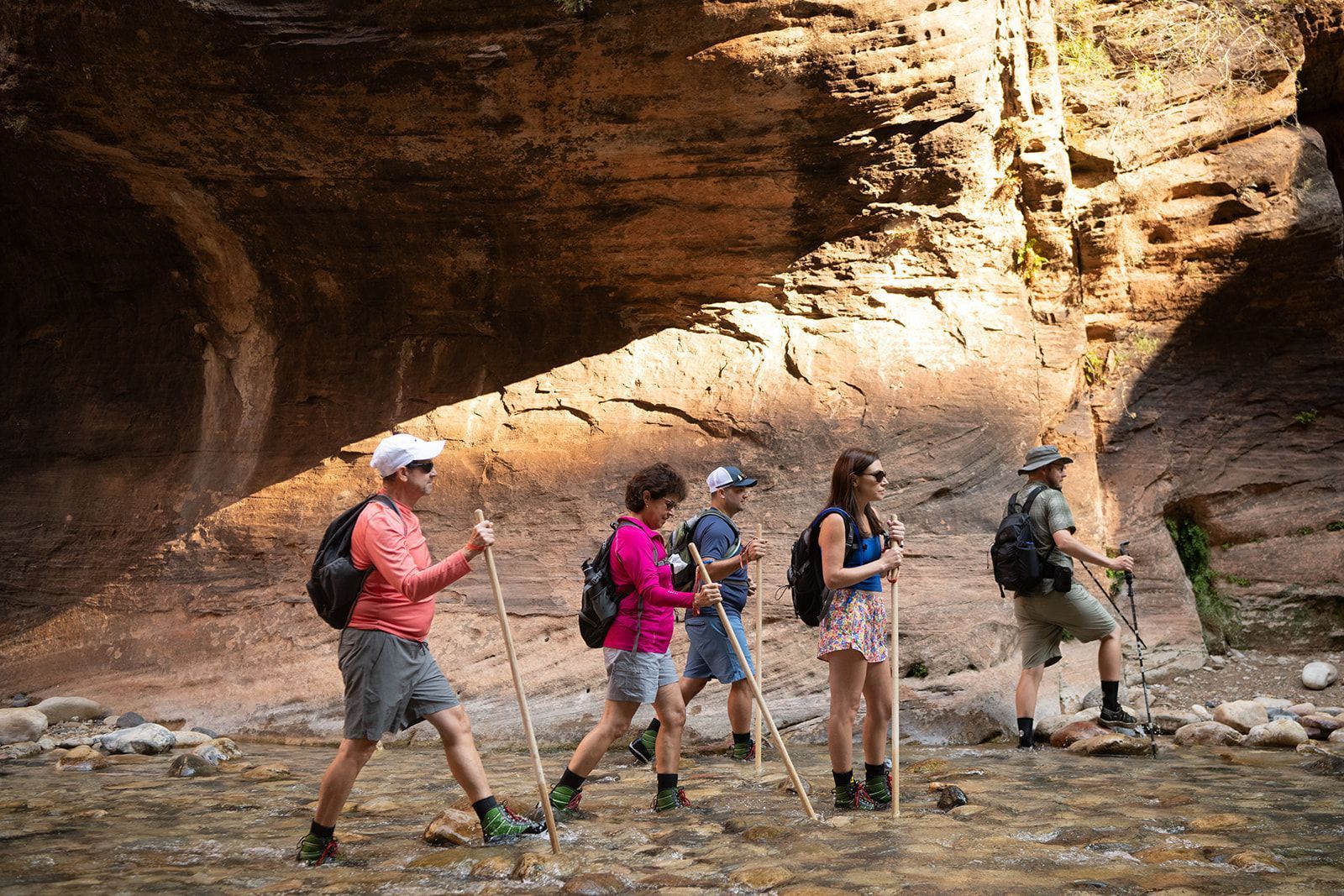A group of people are hiking across a river.
