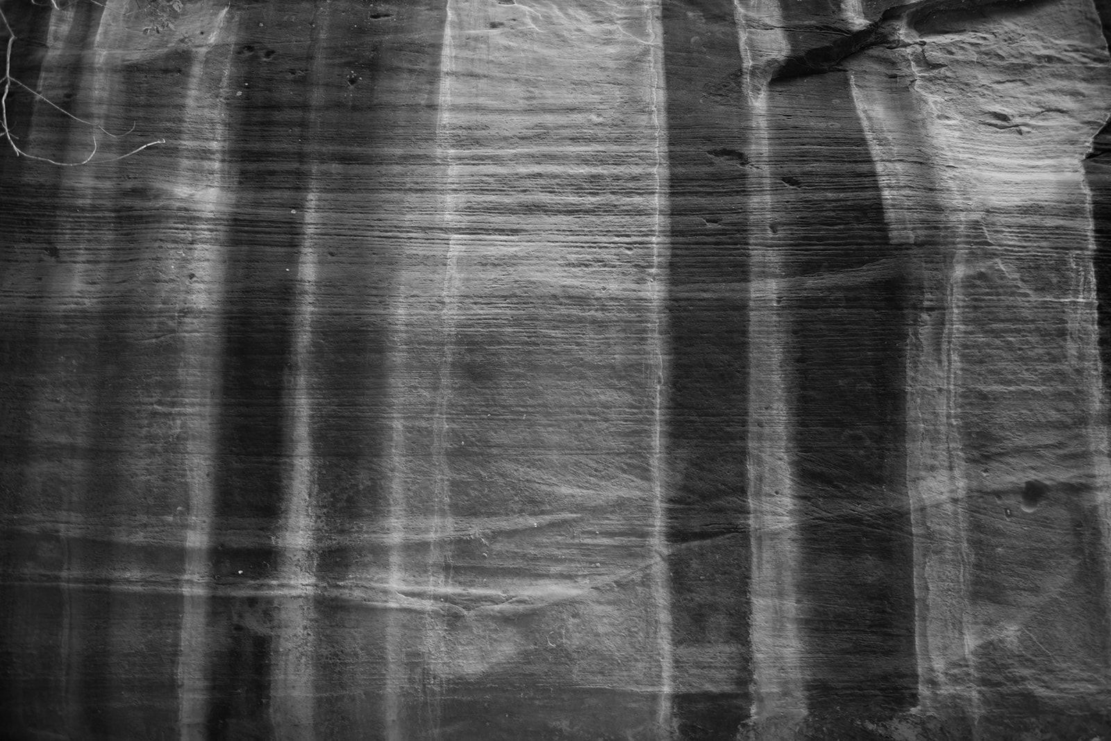 orange rock surfaces with dark markings going down zion national park mountain face