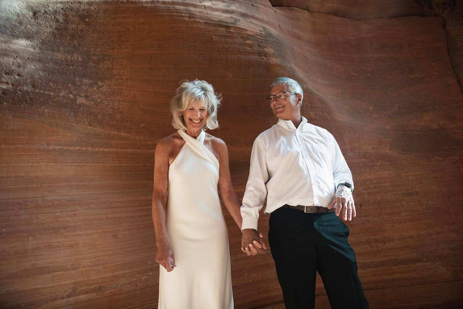 A man and a woman holding hands on their wedding 