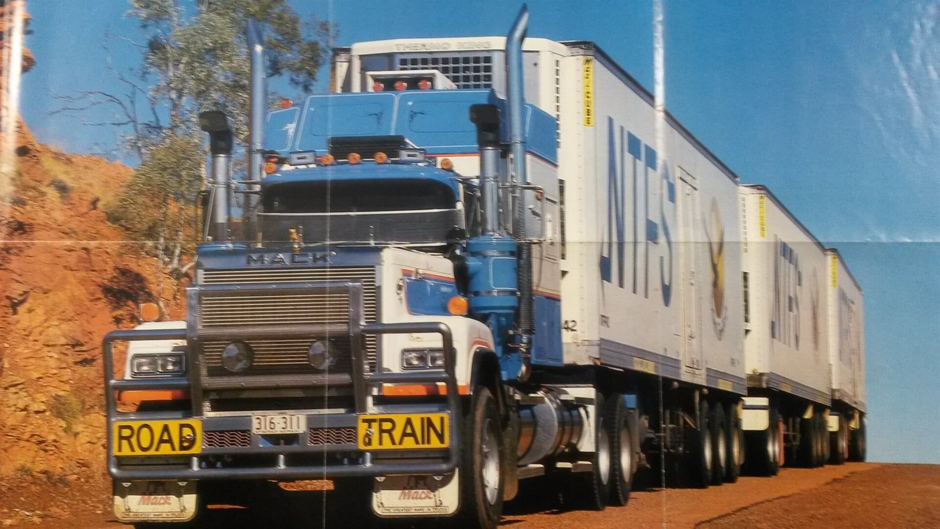 A blue and white semi truck with a road tran sign on the front-Slingshot Haulage in Katherine, NT