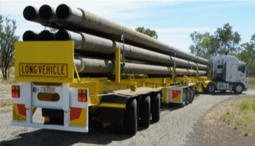 A long vehicle is driving down a dirt road- Slingshot Haulage in Katherine, NT