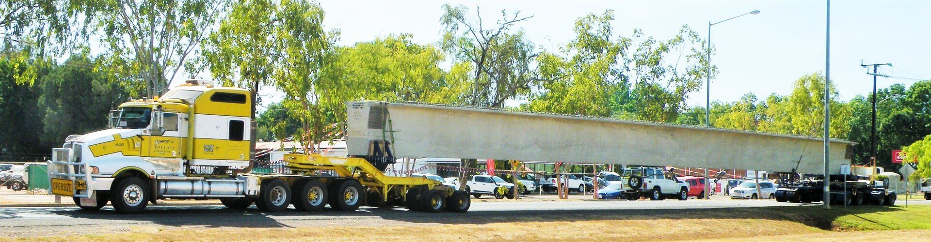 A yellow and white semi truck is parked in a parking lot-Slingshot Haulage in Katherine, NT