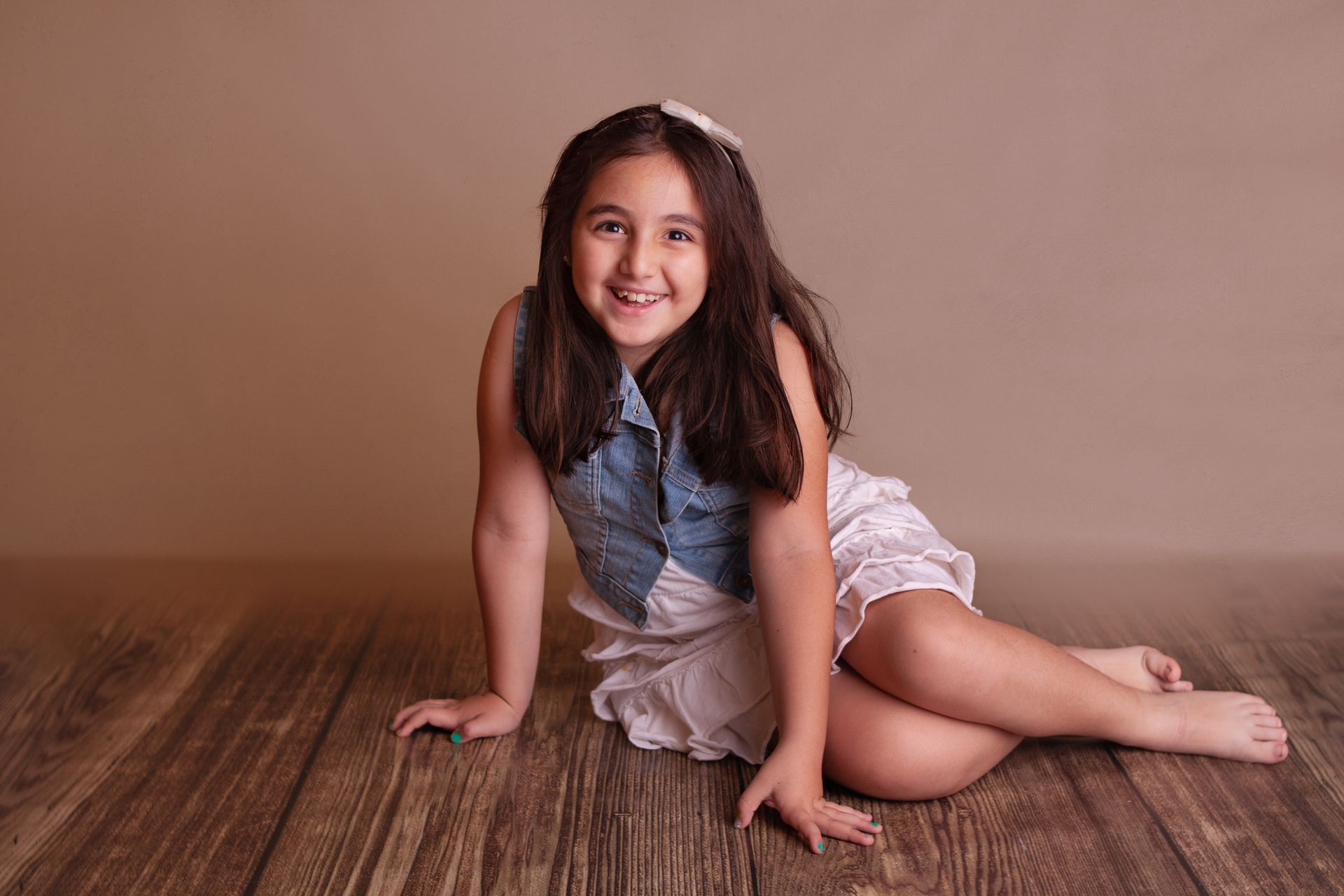 una niña sentada en el piso sonriendo