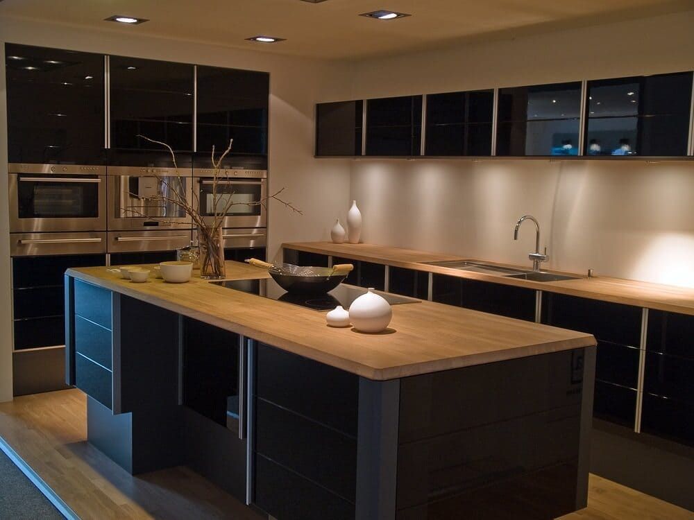 A Kitchen With Black Cabinets And A Large Wooden Island — Lake Macquarie Designer Kitchens In Cessnock, NSW