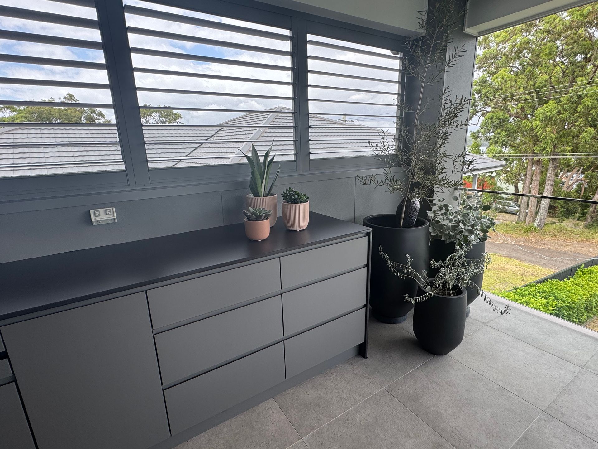 A Kitchen With a Lot of Drawers and Potted Plants on the Counter — Lake Macquarie Designer Kitchens In Morisset, NSW