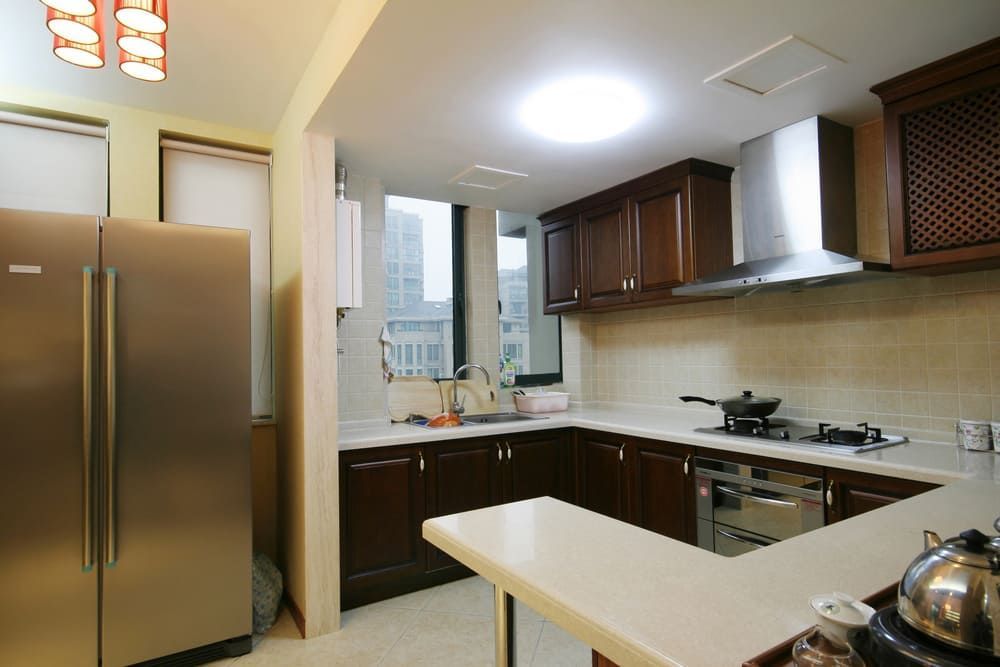 A Kitchen With Stainless Steel Appliances And Wooden Cabinets — Lake Macquarie Designer Kitchens In Watagan Park, NSW