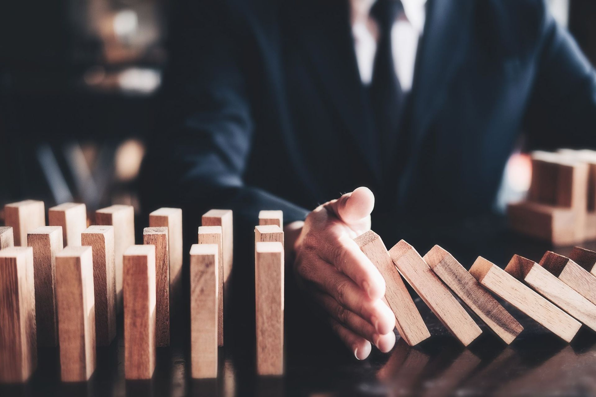 close up of hands protecting blocks representing business liability insurance