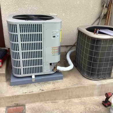 A couple of air conditioners are sitting next to each other on the side of a building.