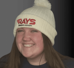 A woman wearing a white beanie with the word rays on it