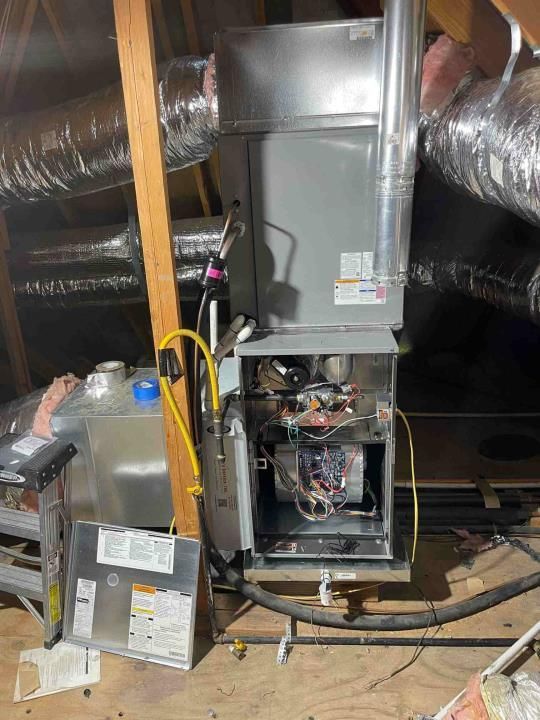 An air conditioner is sitting in the attic of a house.