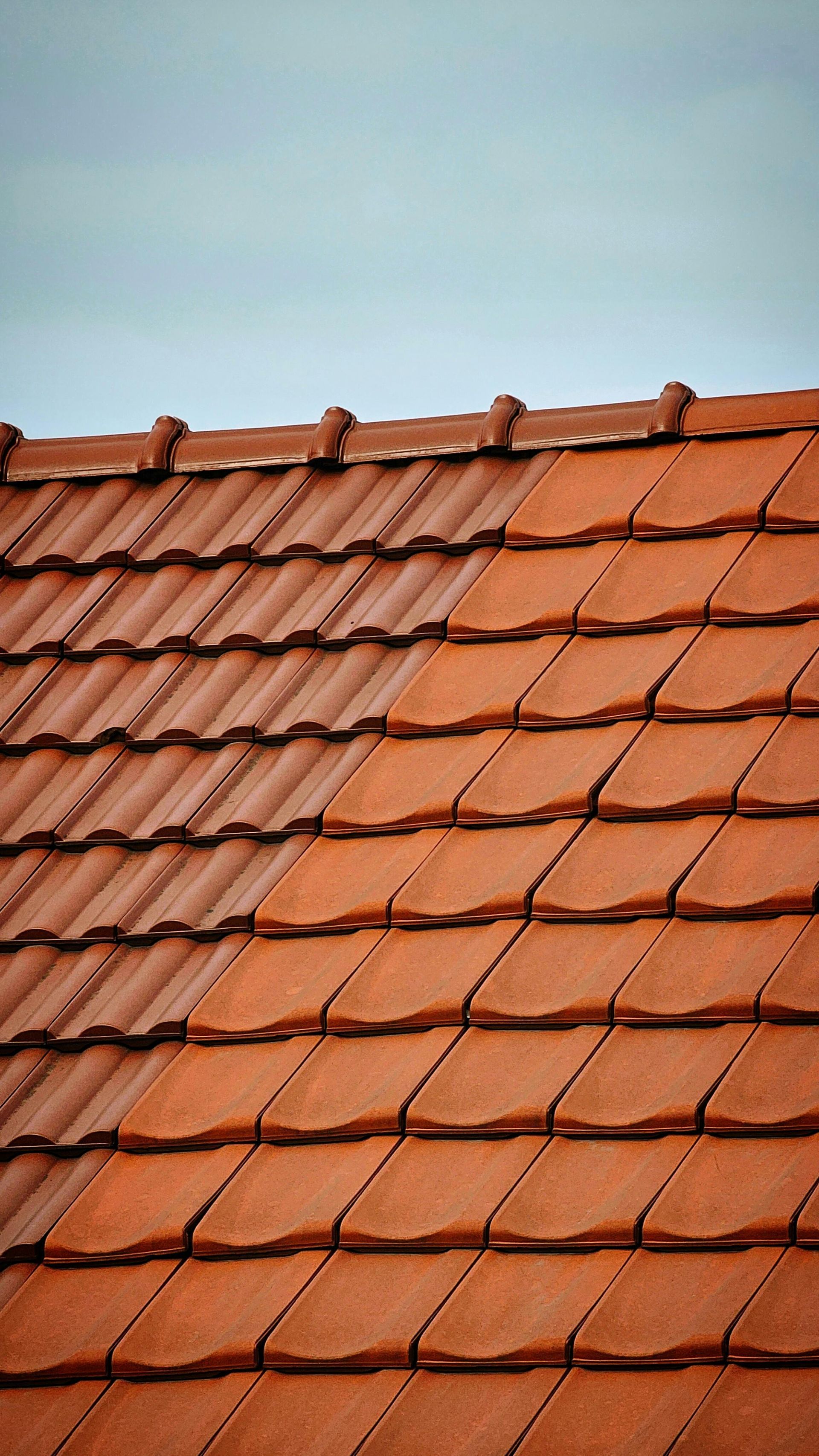 Red clay roof tiles against a cloudy sky