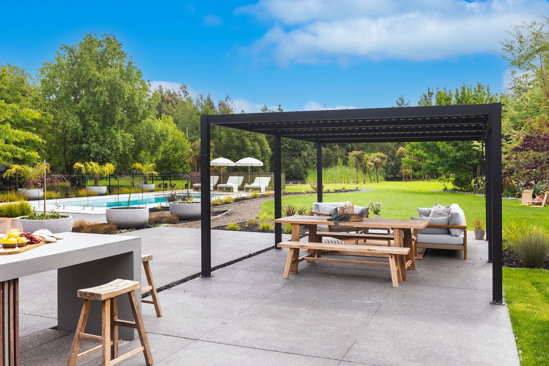 A patio with a table and benches under a pergola