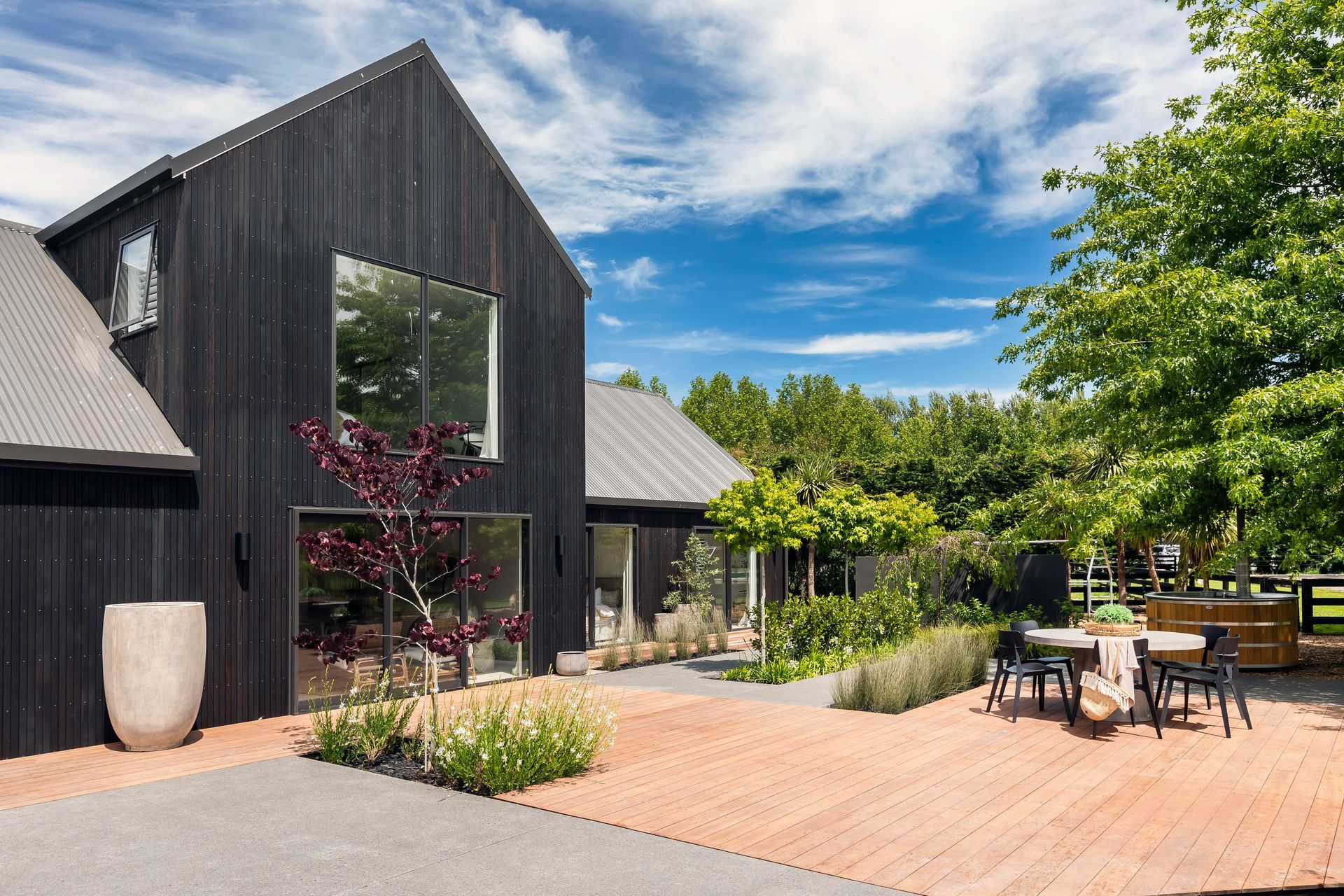 A large black house with a table and chairs in front of it.