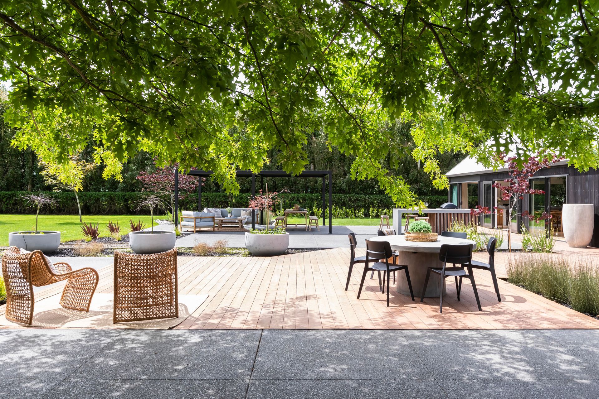 A patio with a table and chairs under a tree.