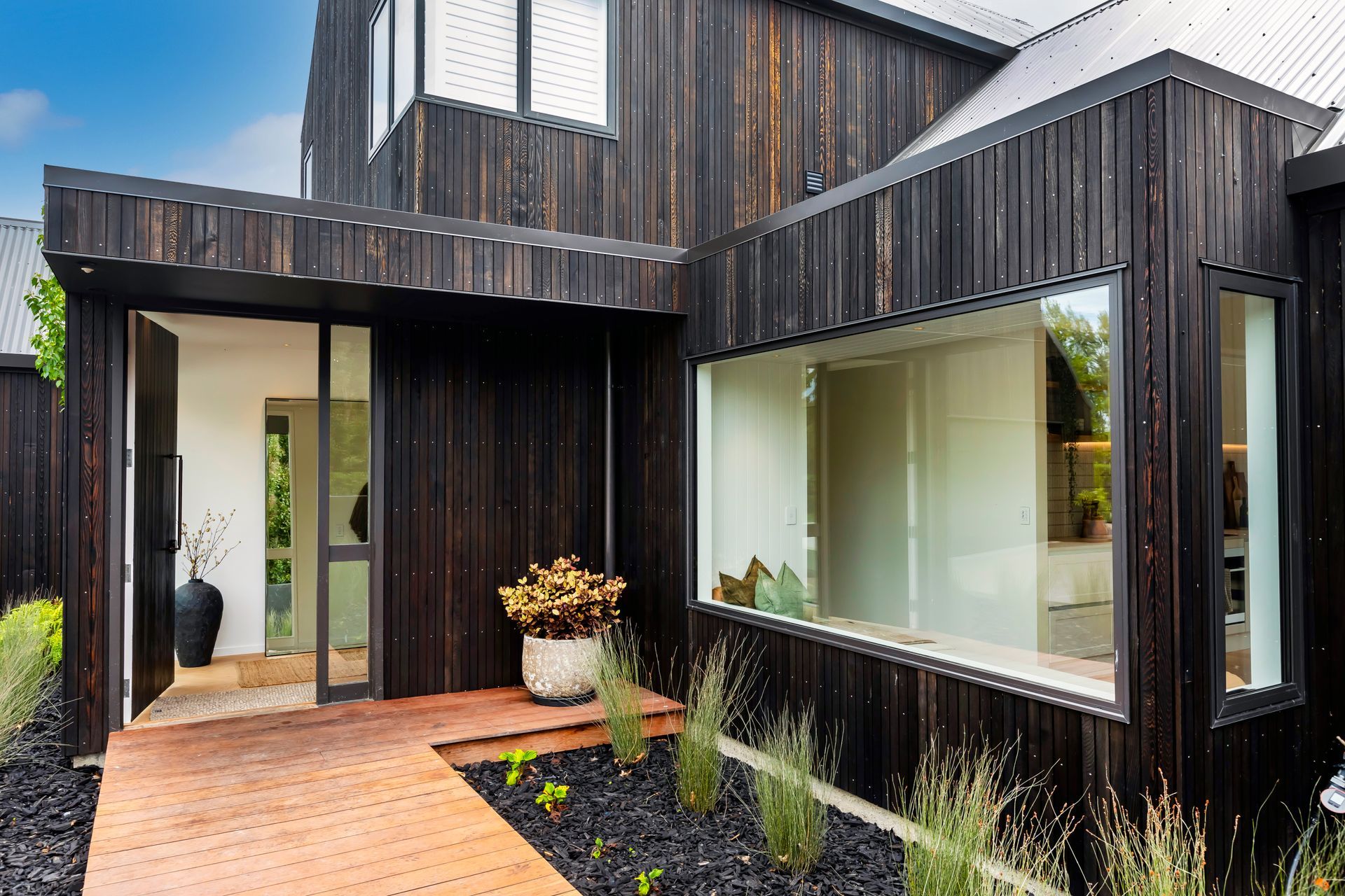 The front of a house with a wooden walkway leading to it.