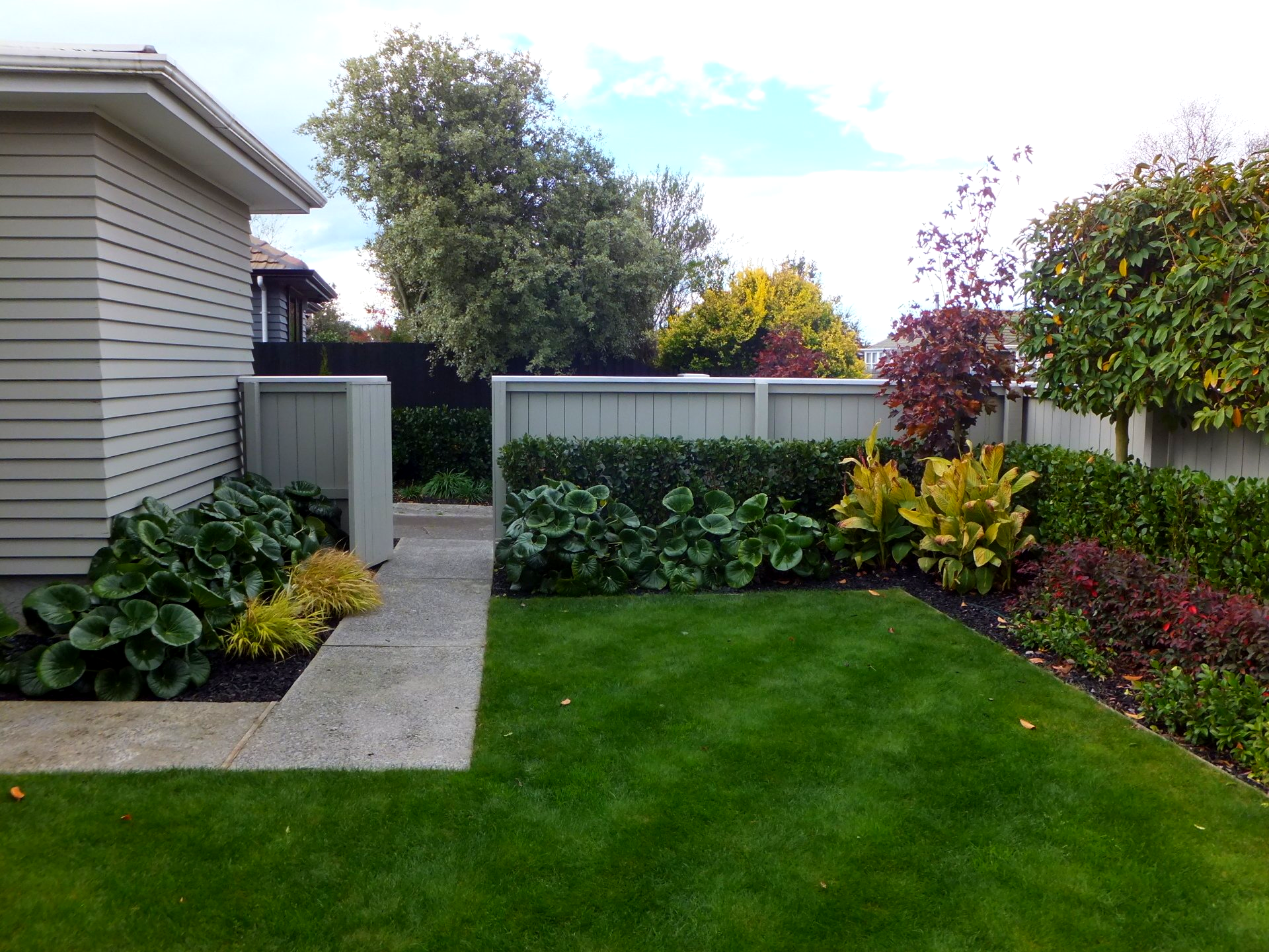 A house with a fence and a lush green lawn