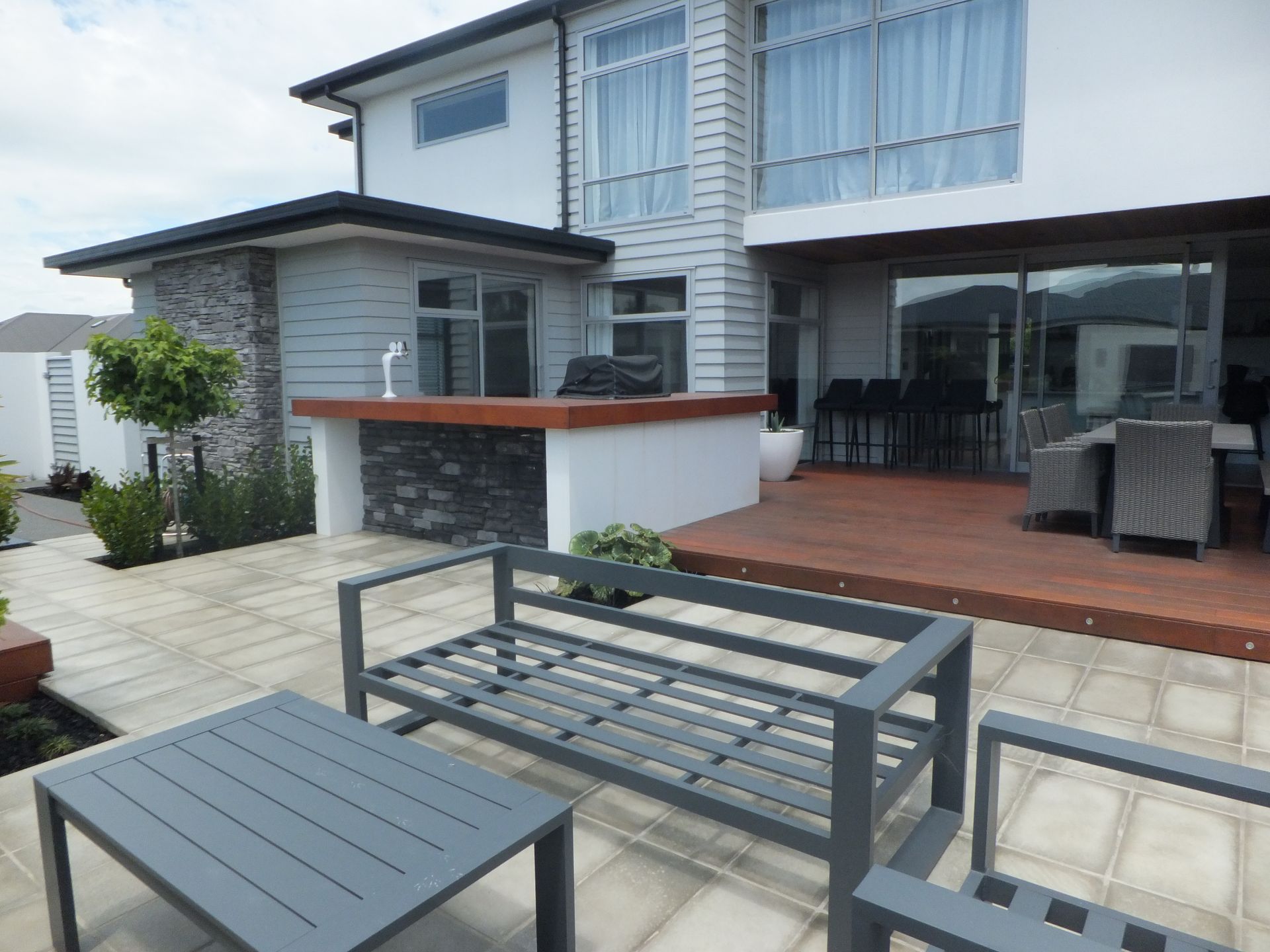 A patio with a couch and a table in front of a house