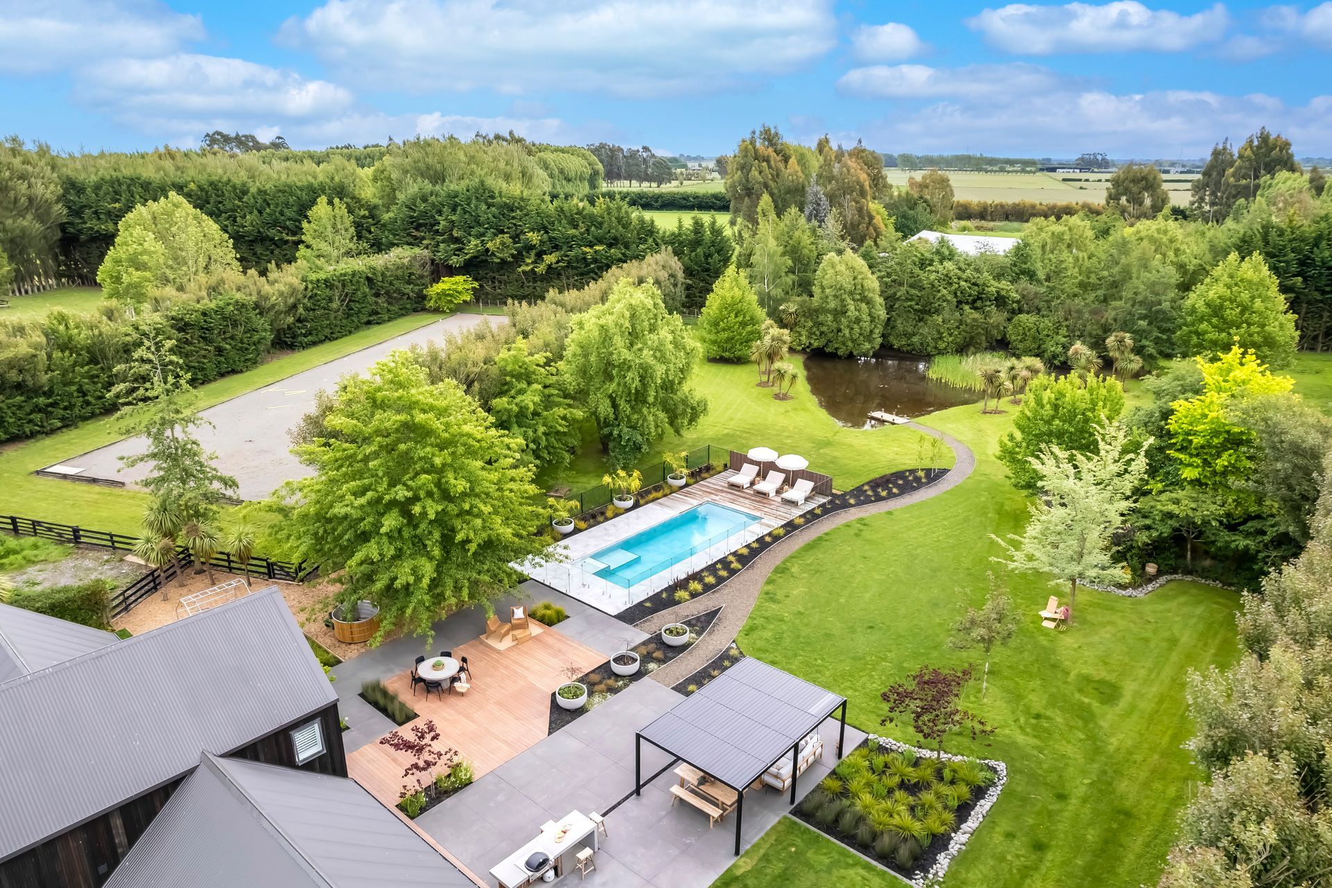 An aerial view of a house with a large swimming pool in the backyard.