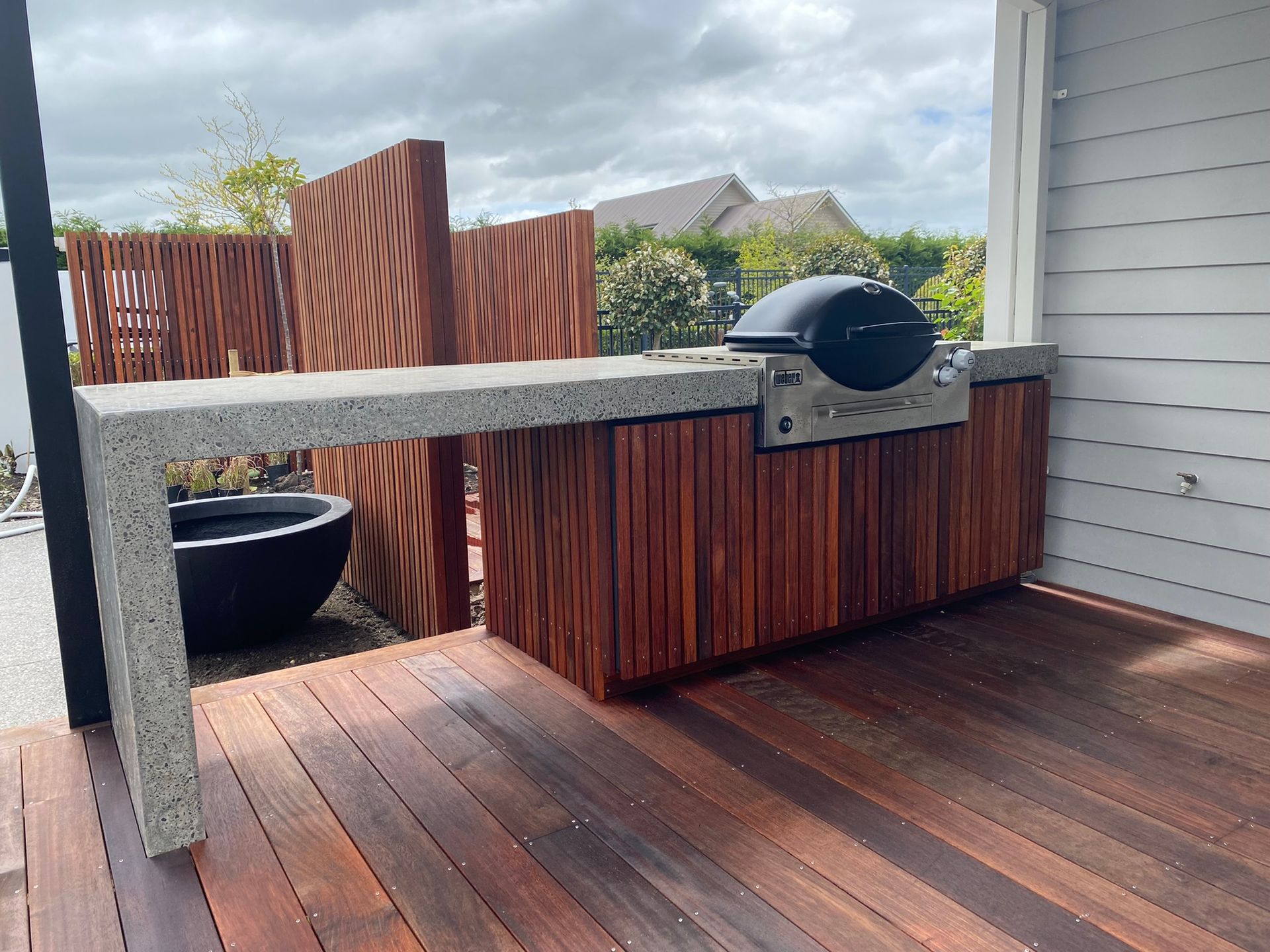 A grill is sitting on top of a wooden deck.