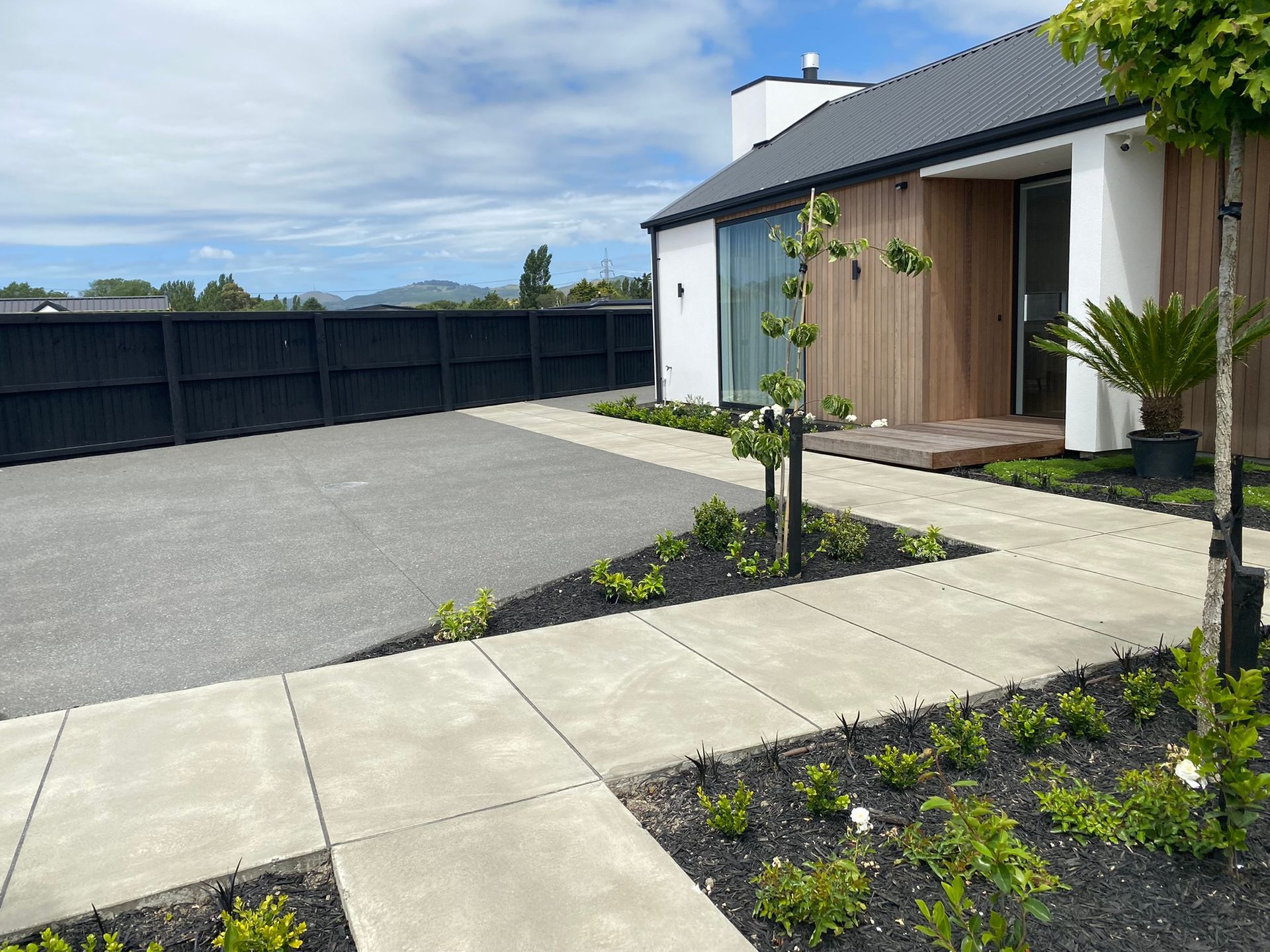 There is a walkway leading to the front of the house.