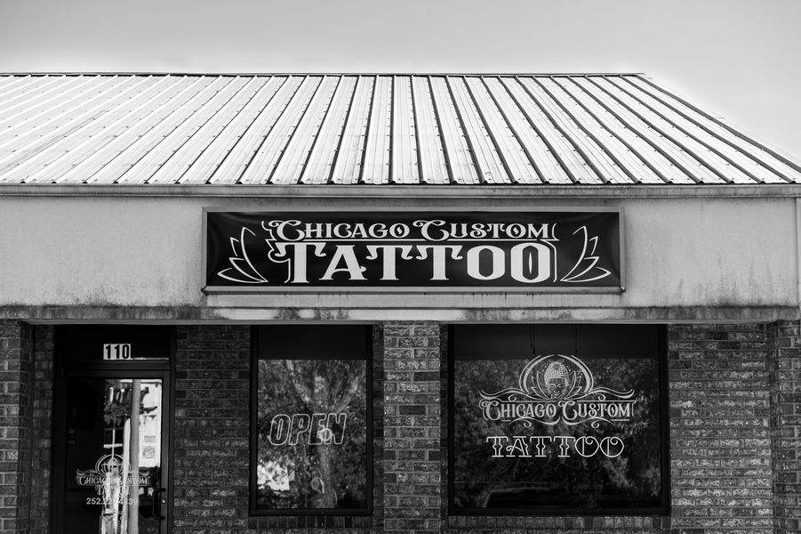 Chicago Custom Tattoo shop exterior. Black and white photo of building front. Signage above and in windows.