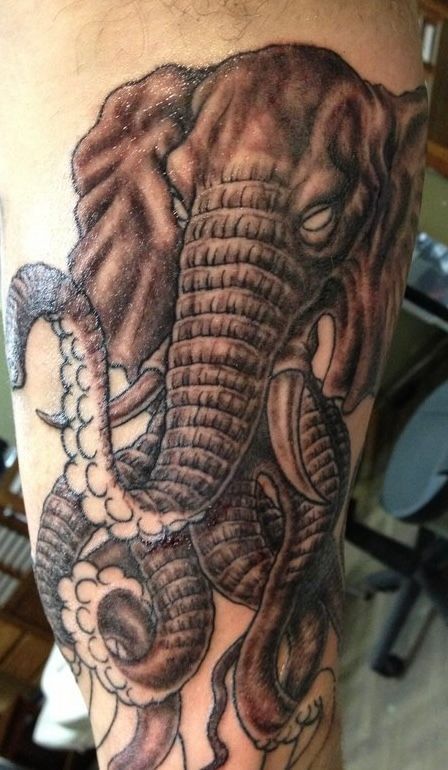 Tattoo on an arm: Elephant head with octopus tentacles, dark grey shading.