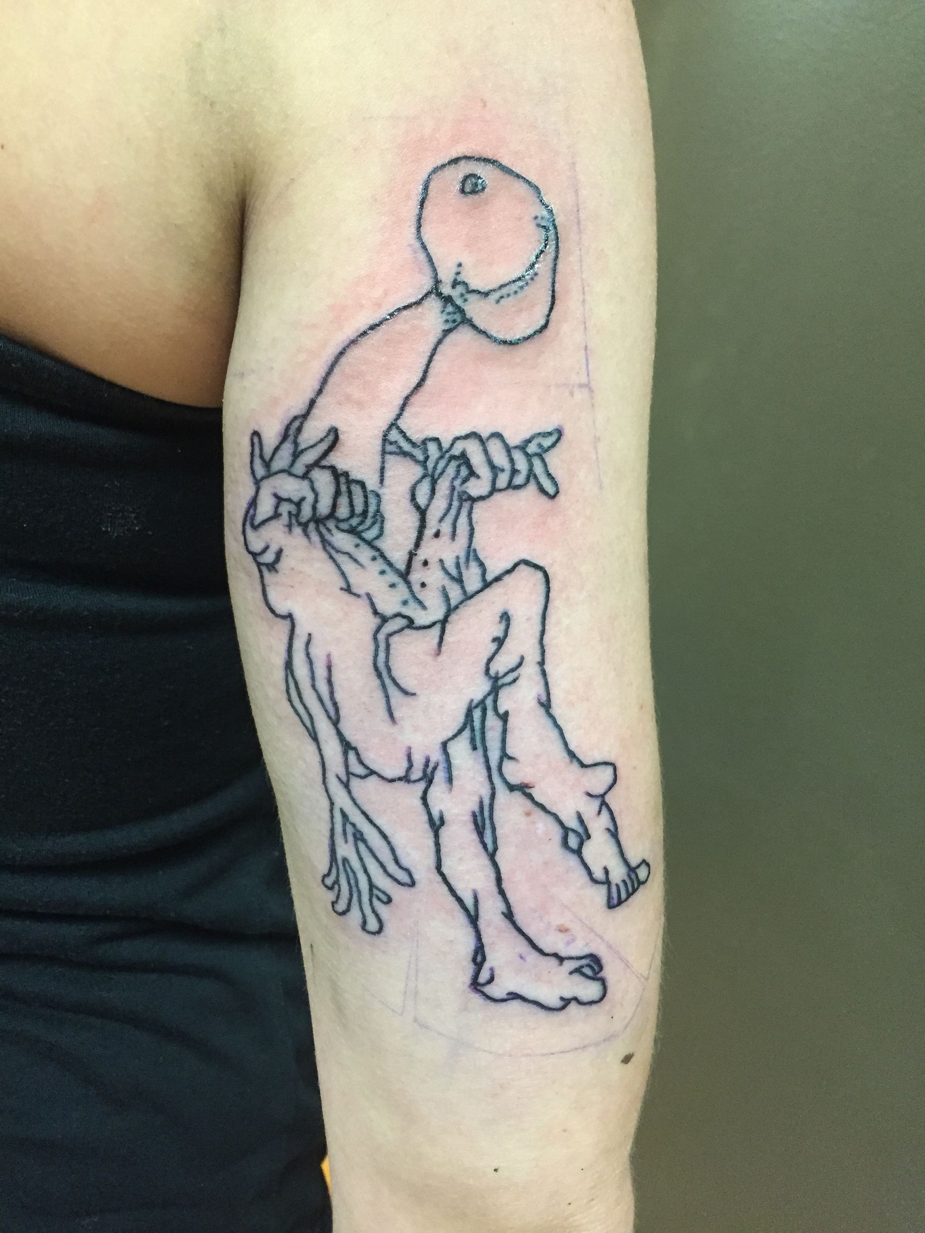 Line art tattoo on arm: stick figure holding another figure, possibly struggling.