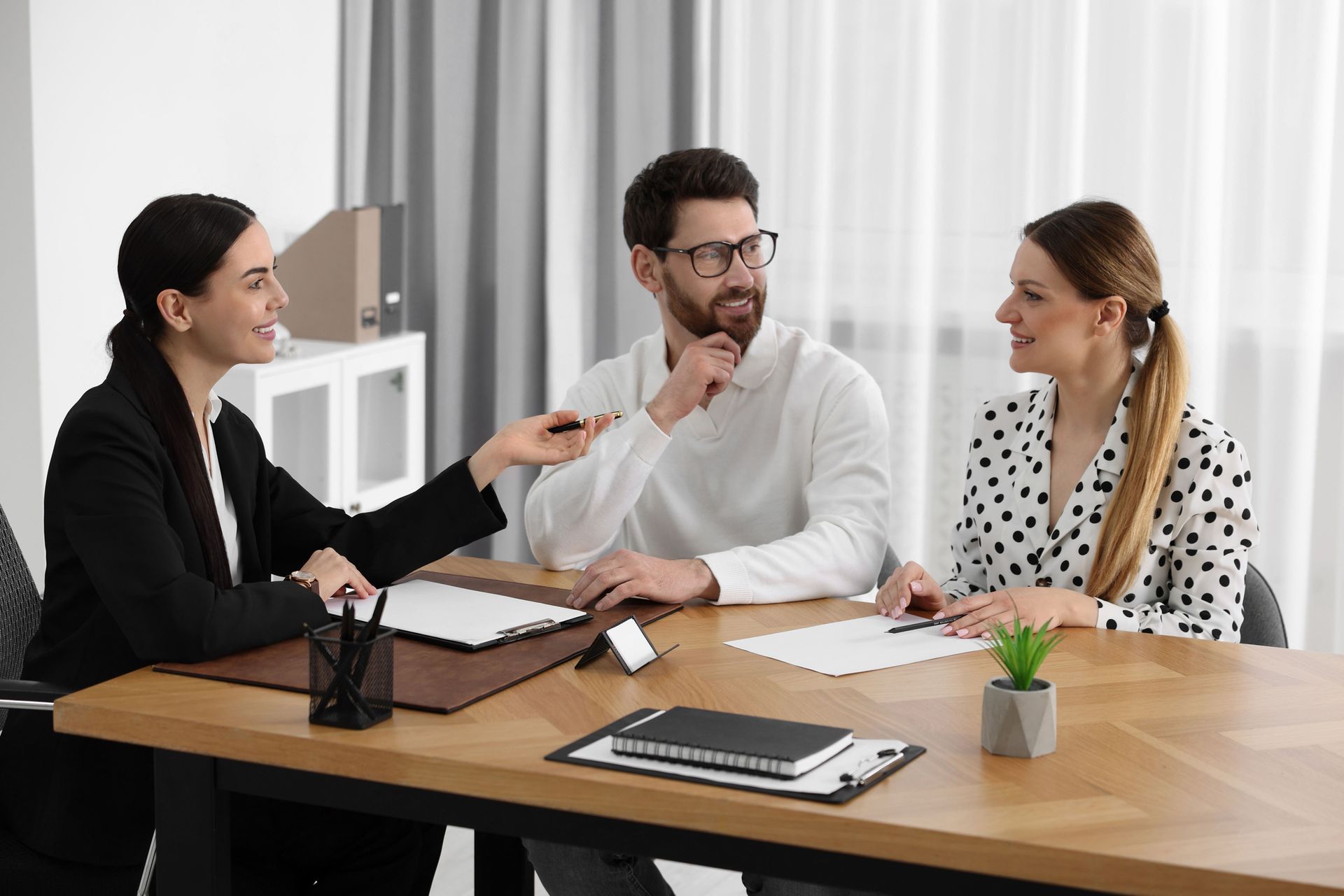 A man and a woman are sitting at a table talking to each other.