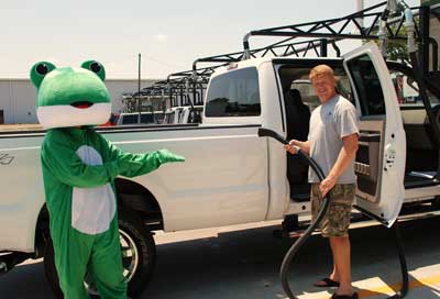 Deluxe Wash — Man Holding a Vacuum Beside Frog Mascot in Lancaster, OH