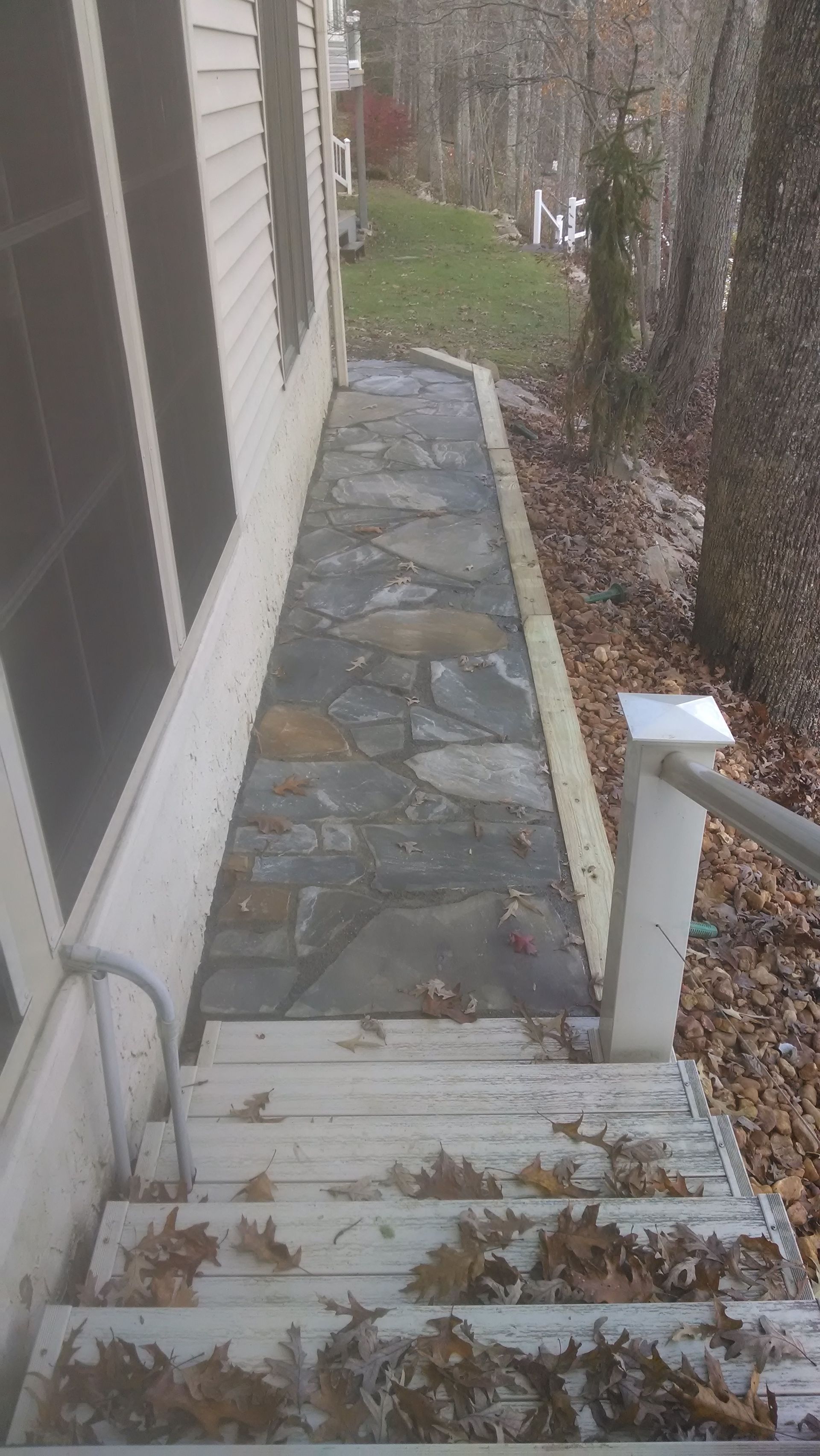 A stone walkway with stairs leading up to a house.