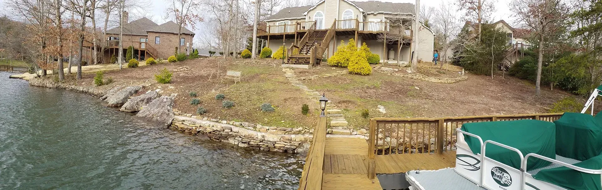 A large house is sitting on a small island next to a body of water.