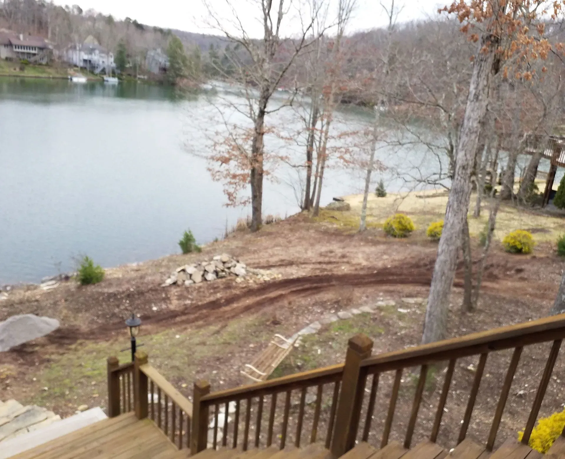 A view of a lake from a deck with stairs leading up to it.