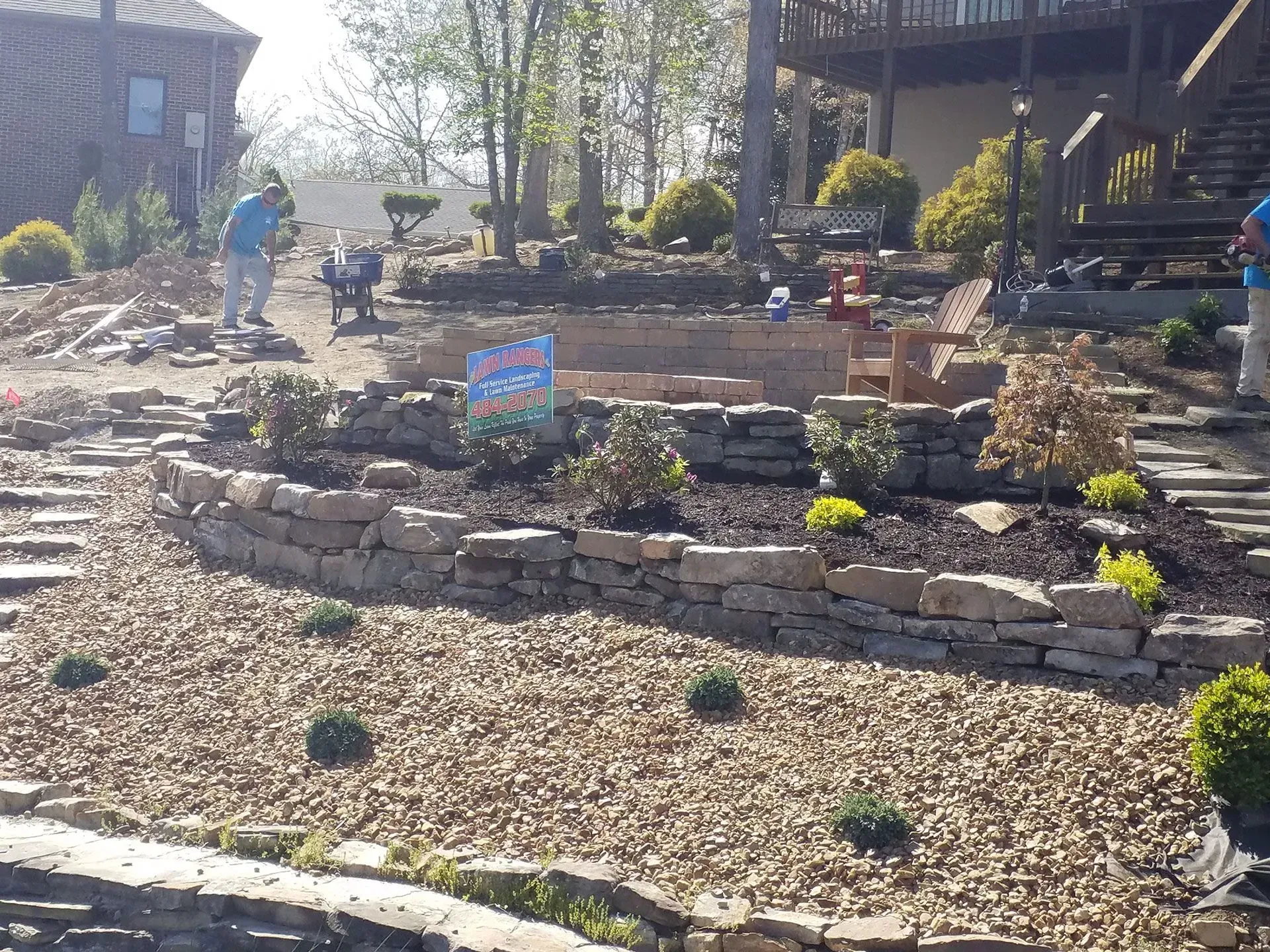 A man is working on a landscaping project in front of a house.